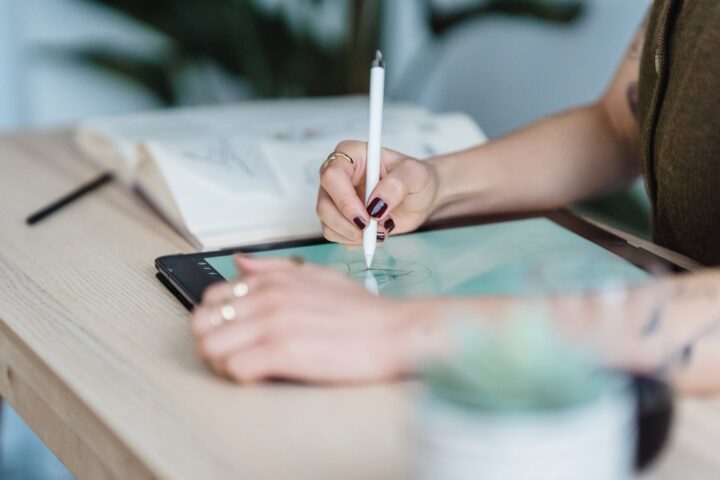 anonymous female designer using tablet for drawing