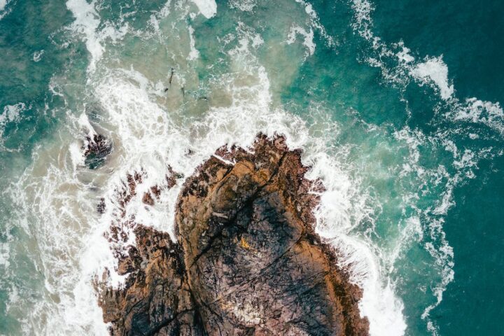 aerial view of waves crashing on rocks