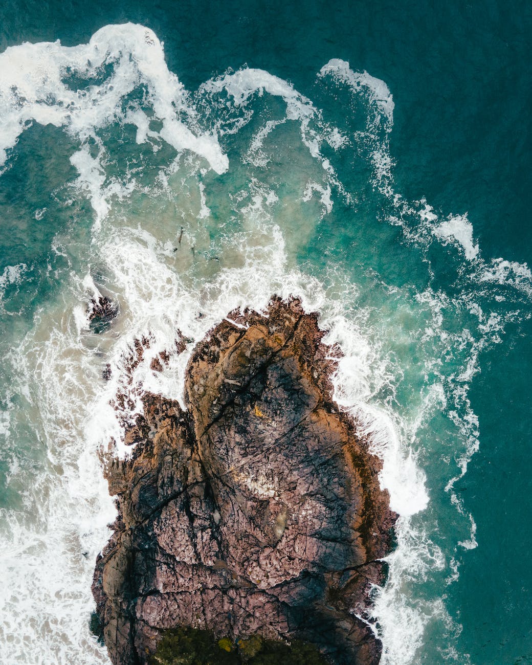 aerial view of waves crashing on rocks