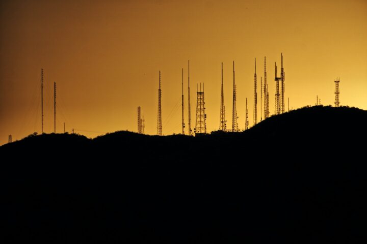 silhouette photo of transmission tower on hill