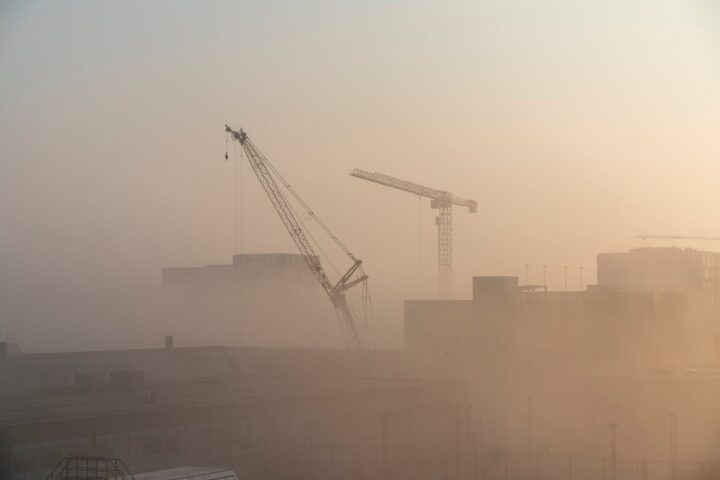 cranes near building during sunset