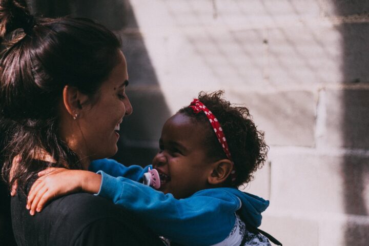 woman holding baby wearing blue jacket