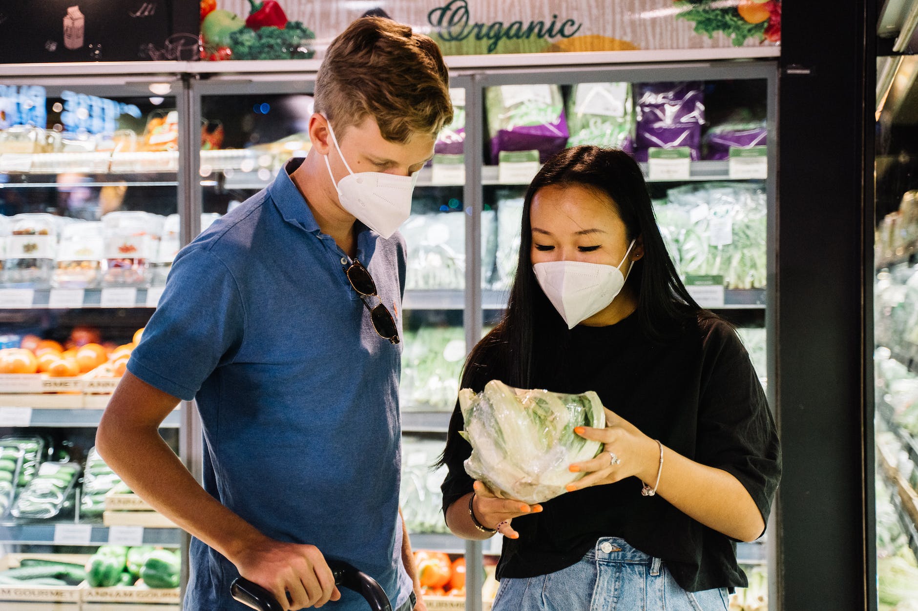 couple with face masks shopping for fresh vegetable