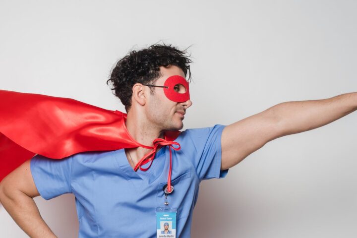 brave doctor in flying superhero cape with fist stretched