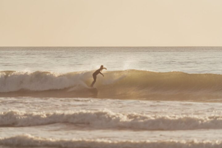 agile surfer riding rough wave on cloudy day