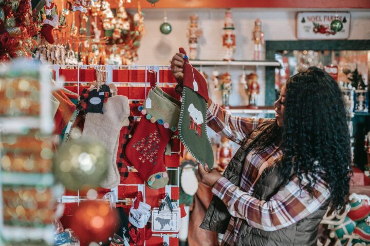 smiling black woman choosing christmas decorations in store