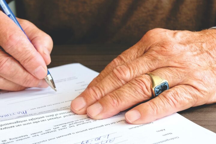 person signing document paper