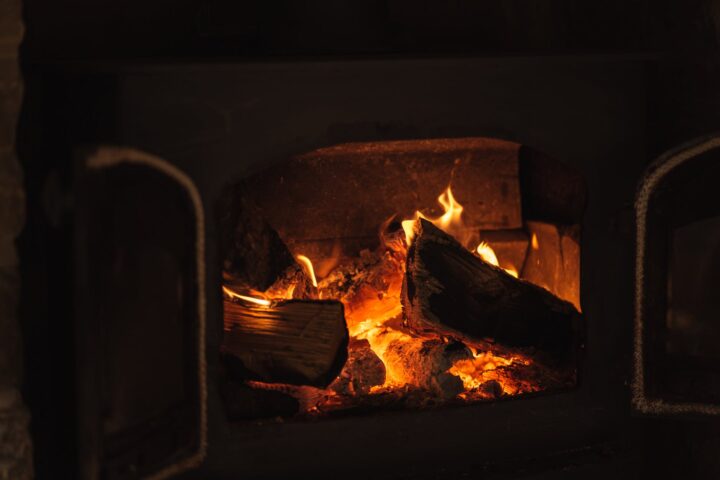 burning fireplace with orange flames in dark house