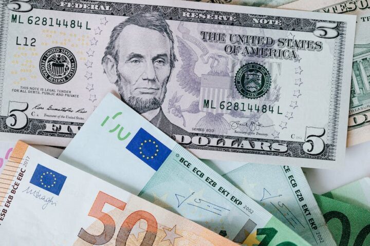 stack of different currency with photo of men and buildings