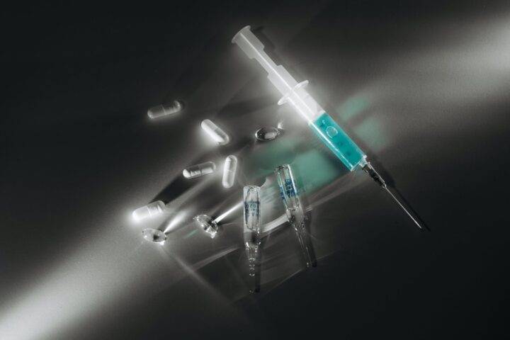 syringe and capsules on white surface