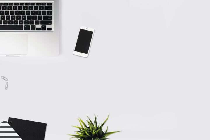 white smartphone beside silver laptop computer