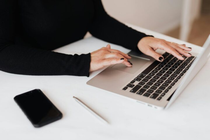 crop faceless woman working on netbook in office