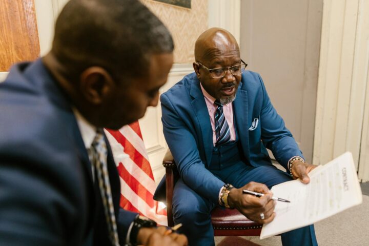 men in business suit looking at the white paper with printed texts